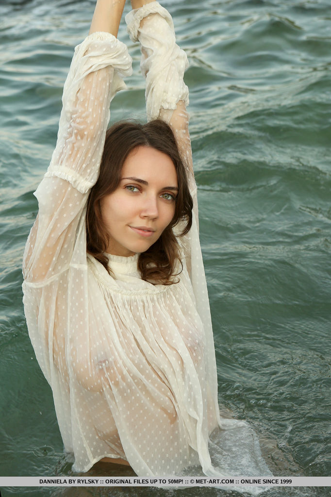 Danniela looks regal as she wears a while lace top. She dips her body into the sea and poses around the rocky shore.