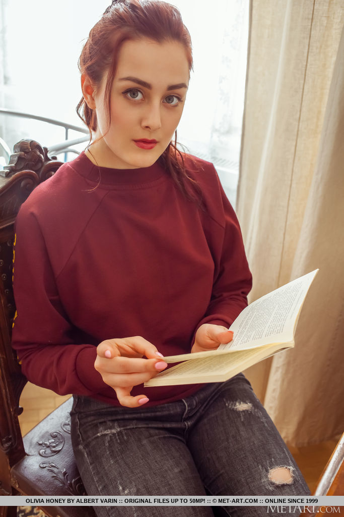 Gorgeous red haired Olivia Honey captivates as she reads a book and takes off her clothes showing off her hairless punani and sexy breasts. 