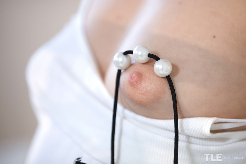 Blue Angel pushes the black thong inside of her white panties, grinding the lace against her clit as she masturbates.