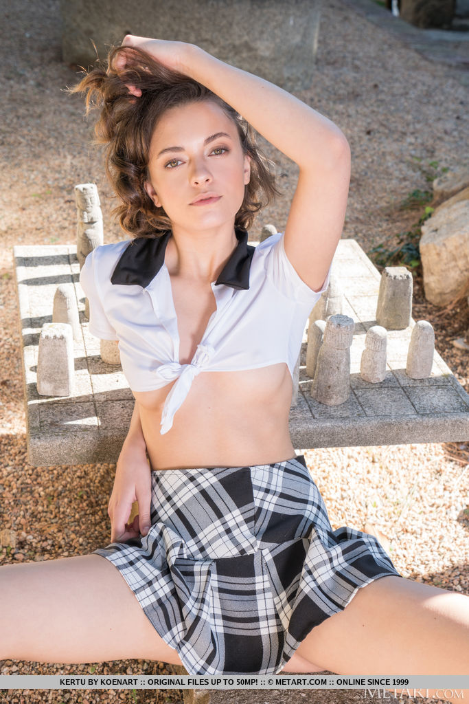 Kertu looks so hot in her sexy school uniform outfit and the more when she spreads her legs sitting on the stone and exposes her shaved cunt.